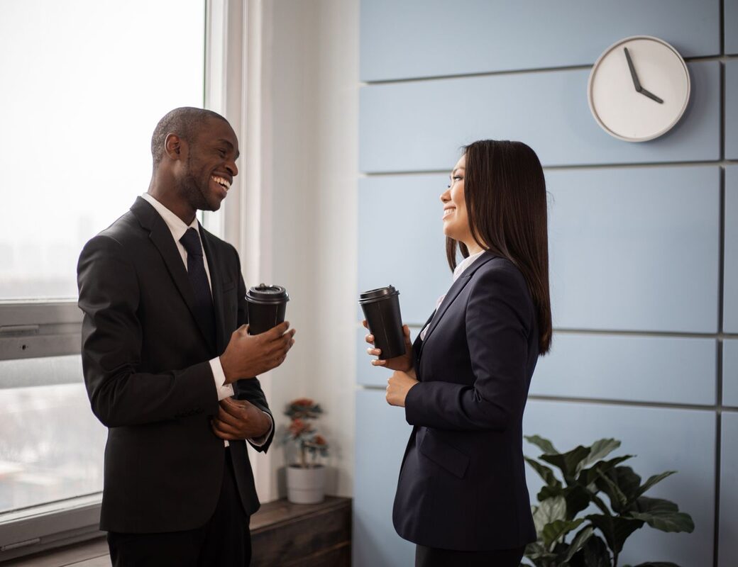 Two people in a focused one-on-one mentoring conversation over coffee